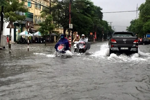 Nhiều tuyến đường thành phố Vinh bị ngập khiến các phương tiện tham gia giao thông gặp nhiều khó khăn. (Ảnh: Tá Chuyên/TTXVN)