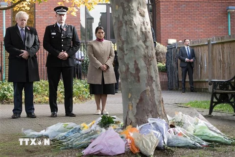 Thủ tướng Anh Boris Johnson, Cảnh sát trưởng hạt Essex Ben-Julian Harrington và Bộ trưởng Nội vụ Anh Priti Patel (phải) tưởng niệm các nạn nhân thiệt mạng trong xe công-ten-nơ được tìm thấy ở thị trấn Grays, hạt Essex, ngày 28/10/2019. (Ảnh: AFP/TTXVN)