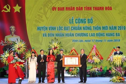 Đồng chí Nguyễn Văn Bình Trưởng ban Kinh tế Trung ương trao Bằng công nhân huyện Vĩnh Lộc đạt chuẩn huyện nông thôn mới năm 2019. (Ảnh: Duy Hưng/TTXVN)