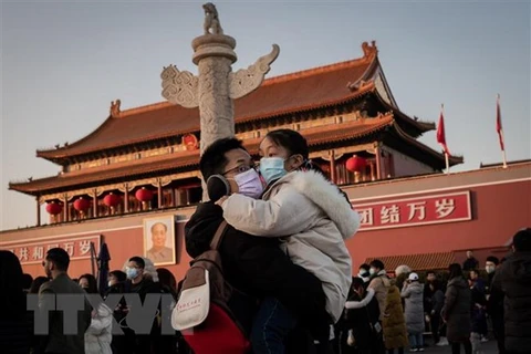 Khách thăm quan tại quảng trường Thiên An Môn ở Bắc Kinh, Trung Quốc đeo khẩu trang đề phòng virus corona mới. (Ảnh: AFP/TTXVN