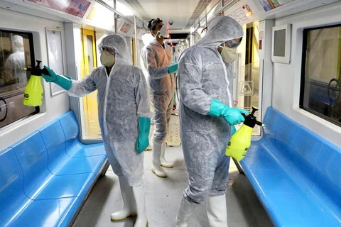 Các nhân viên y tế ở Đan Mạch khử trùng tàu điện ngầm. (Ảnh: Arabiya)