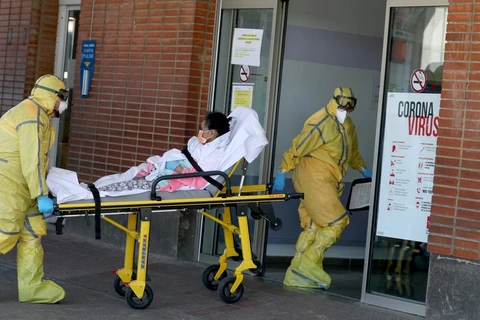 Nhân viên y tế tại Tây Ban Nha đưa bệnh nhân nhiễm COVID-19 vào viện. (Ảnh: Reuters)