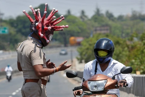 Cảnh sát Ấn Độ đeo mũ mô phỏng virus corona để nhắc nhở người dân ở nhà. (Ảnh: Reuters)