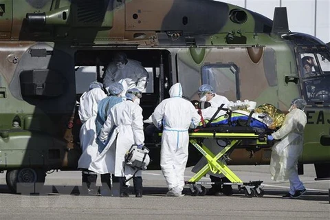 Nhân viên y tế chuyển bệnh nhân nhiễm COVID-19 lên máy bay trực thăng tại Strasbourg , Pháp, ngày 30/3/2020. (Nguồn: AFP/TTXVN)
