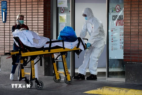 Nhân viên y tế chuyển bệnh nhân nhiễm COVID-19 tới bệnh viện ở Leganes, Tây Ban Nha, ngày 26/3/2020. (Ảnh: AFP/TTXVN)