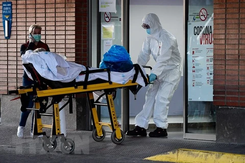 Nhân viên y tế chuyển bệnh nhân nhiễm COVID-19 tới bệnh viện ở Leganes, Tây Ban Nha. (Ảnh: AFP/TTXVN)