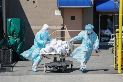 Nhân viên y tế chuyển thi thể bệnh nhân COVID-19 tới nhà xác dã chiến của bệnh viện Wyckoff ở Brooklyn, New York, Mỹ. (Ảnh: AFP/TTXVN)