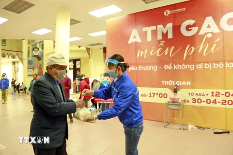 Người dân đến nhận gạo tại cây ATM gạo. (Ảnh: Trần Việt/TTXVN)