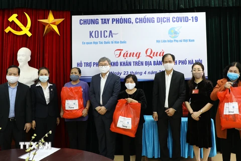 Ông Cho Han-Deok, Giám đốc quốc gia KOICA Việt Nam (thứ tư từ trái sang) trao quà cho phụ nữ có hoàn cảnh khó khăn tại Hà Nội. Ảnh: TTXVN