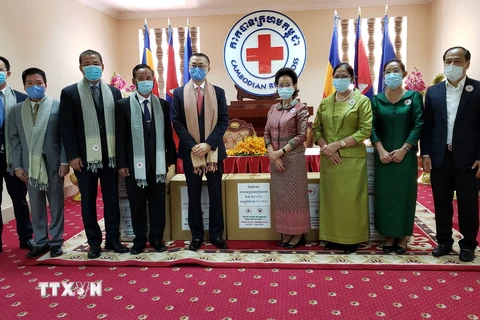 Đại diện Hội chữ thập đỏ Việt Nam Đại sứ Vũ Quang Minh ký bàn giao và trao quà tặng thiết bị y tế cho Hội chữ thập đỏ Campuchia. (Ảnh: PV/TTXVN)
