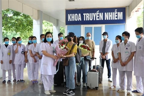 Lãnh đạo Bệnh viện Đa khoa tỉnh Ninh Bình tặng hoa chúc mừng bệnh nhân được chữa khỏi bệnh. (Ảnh: Đức Phương/TTXVN)