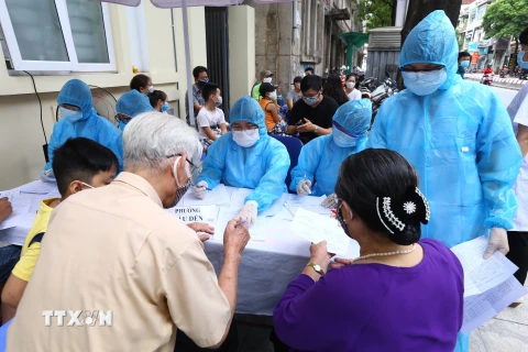 Người về từ Đà Nẵng làm thủ tục xét nghiệm nhanh tại phường Bách Khoa và phường Cầu Dền (quận Hai Bà Trưng) sáng 01/8/2020. (Ảnh: Minh Quyết/TTXVN)