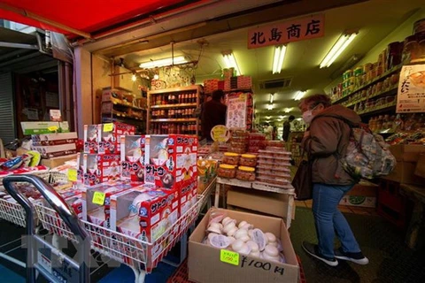 Khách hàng tới một cửa hàng bán thực phẩm ở Tokyo. (Ảnh: AFP/TTXVN)