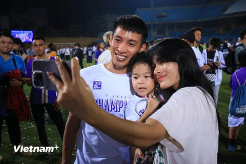 Tiền vệ Đỗ Hùng Dũng ăn mừng chức vô địch V-League 2022 bên gia đình nhỏ. (Ảnh: PV/Vietnam+) 
