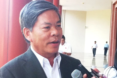 Bộ trưởng Nguyễn Minh Quang trả lời phỏng vấn báo chí bên hành lang Quốc hội. (Ảnh: Thúy Hà/Vietnam+).