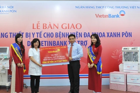 Chủ tịch Hội đồng quản trị VietinBank trao các thiết bị y tế cho Giám đốc Bệnh viện Xanh Pôn. (Nguồn: VietinBank).