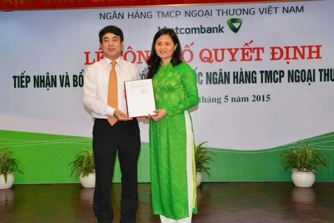 Chủ tịch Hội đồng quản trị Nghiêm Xuân Thành trao quyết định tiếp nhận và bổ nhiệm cho bà Đinh Thị Thái. (Nguồn: Vietcombank)
