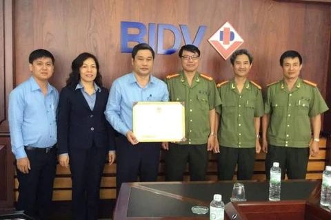 Cơ quan an ninh điều tra - Công an tỉnh Khánh Hòa trao bằng khen cho lãnh đạo BIDV Khánh Hòa. (Nguồn: BIDV)