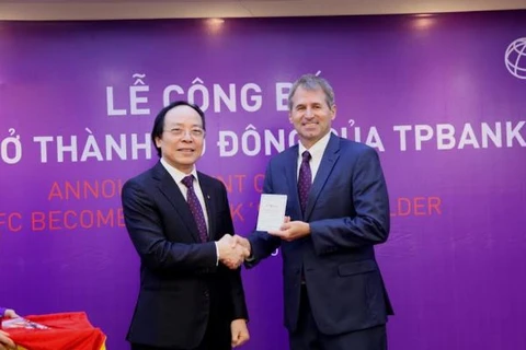Ông Đỗ Minh Phú (bên trái), Chủ tịch HĐQT TPBank trao sổ cổ đông cho đại diện IFC. (Nguồn: TPBank)