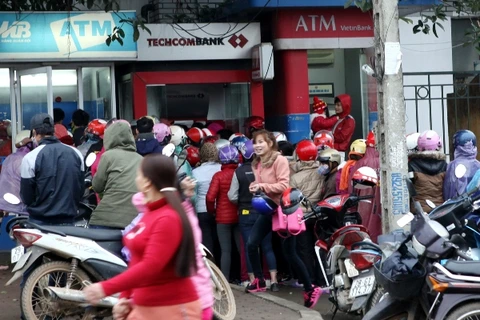 Người dân xếp hàng chờ rút tiền tại cây ATM trên đường Hòa Lạc. (Ảnh: Ngọc Hà: TTXVN)
