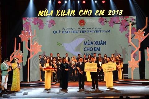 Ông Đào Minh Tuấn, Phó Tổng Giám đốc Vietcombank (hàng đầu, đứng giữa) trao tặng số tiền ủng hộ Quỹ Bảo trợ trẻ VN. (Nguồn: Vietcombank)