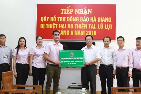 Phó Tổng giám đốc NHCSXH Nguyễn Đức Hải (thứ 4 từ trái sang) trao quà cho lãnh đạo tỉnh Hà Giang. (Nguồn: NHCSXH)