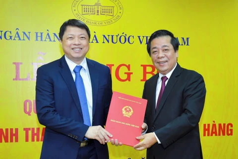 Phó Thống đốc Nguyễn Kim Anh (phải) trao Quyết định cho ông Nguyễn Văn Du. (Nguồn: NHNN)