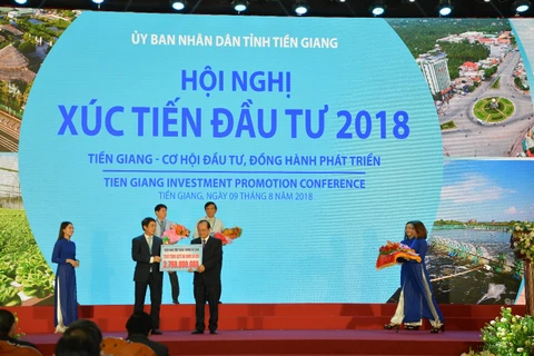 Ông Nghiêm Xuân Thành, Chủ tịch HĐQT Vietcombank (bên trái) trao tượng trưng số tiền 3,75 tỷ đồng của Vietcombank ủng hộ công tác an sinh xã hội tỉnh Tiền Giang. (Nguồn: Vietcombank)