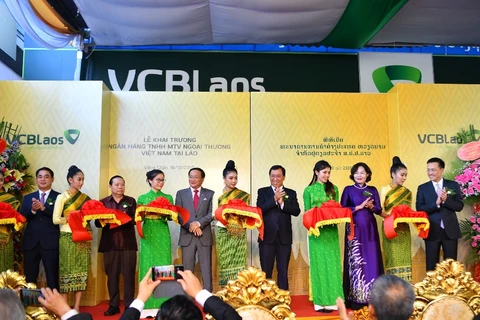 Các đại biểu cắt băng khai trương ngân hàng Vietcombank Lào. (Ảnh: T.H/Vietnam+)