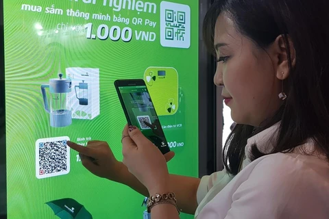 Khách hàng thanh toán trên app của Vietcombank. (Ảnh: Thúy Hà/Vietnam+)