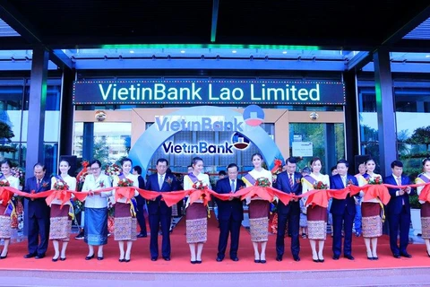 Các đại biểu cắt băng khai trương trụ sở VietinBank Lào. (Ảnh: Phạm Kiên/Vietnam+)
