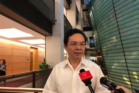 Đại biểu Hoàng Văn Cường, đoàn thành phố Hà Nội trả lời báo chí bên hành lang Quốc hội. (Ảnh: T.H/Vietnam+)