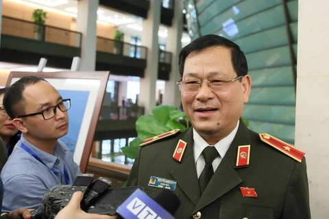 Thiếu tướng Nguyễn Hữu Cầu trả lời báo chí bên hành lang Quốc hội. (Ảnh: PV/Vietnam+)