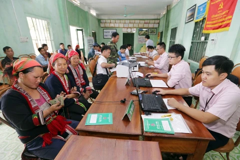 Các hộ gia đình có con là học sinh sinh viên nhận vốn vay ưu đãi tại các điểm giao dịch của Ngân hàng Chính sách. (Ảnh: CTV/Vietnam+)