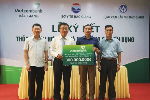 Lãnh đạo Vietcombank trao tiền ủng hộ cho Sở Y tế Bắc Giang để phục vụ cho công tác phòng, chống dịch COVID-19. (Ảnh: Vietnam+)