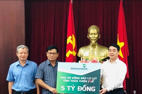 Ông Nghiêm Xuân Thành, Chủ tịch Hội đồng quản trị Vietcombank (ngoài cùng bên phải) trao số tiền 5 tỷ đồng ủng hộ đồng bào tỉnh Thừa Thiên-Huế. (Ảnh: Vietnam+)