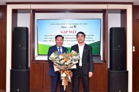Ông Nghiêm Xuân Thành - Chủ tịch HĐQT Vietcombank (bên phải) tặng hoa chúc mừng ông Lại Hữu Phước được bầu làm Trưởng Ban kiểm soát. (Ảnh: Vietnam+)