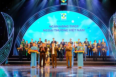 Đại diện Vietcombank nhận biểu trưng Thương hiệu quốc gia từ ban tổ chức. (Ảnh: Vietnam+)