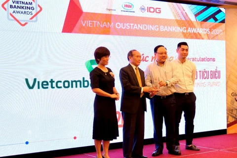 Ông Phạm Anh Tuấn - thành viên Hội đồng quản trị (thứ 2 từ phải sang) cùng đại diện Vietcombank nhận giải thưởng từ ban tổ chức. (Ảnh: Vietnam+)