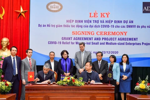 Ông Nguyễn Hồng Quân, Phó Tổng giám đốc TPBank (bên trái) ký cam kết tham gia Hiệp định. (Ảnh: Vietnam+)