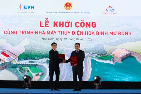 Chủ tịch HĐQT Vietcombank Nghiêm Xuân Thành (trái) trao hợp đồng tài trợ tín dụng cho đại diện EVN. (Ảnh: Vietnam+)