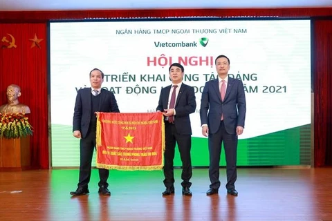 Thừa ủy quyền của Thủ tướng Chính phủ, Phó Thống đốc NHNN Đoàn Thái Sơn trao Cờ thi đua của Thủ tướng Chính phủ cho Vietcombank tại Hội nghị triển khai hoạt động kinh doanh năm 2021. (Ảnh: Vietnam+)