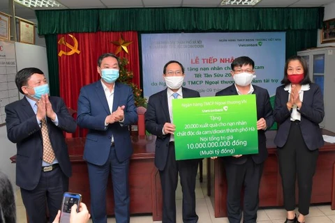 Đại diện Vietcombank trao biển tượng trưng số tiền 10 tỷ đồng quà Tết cho 20.000 nạn nhân chất đôc da cam/dioxin thành phố Hà Nội. (Ảnh: Vietnam+)