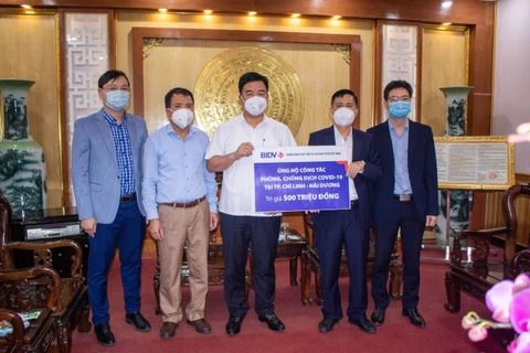 Lãnh đạo BIDV trao tặng ủng hộ phòng chống COVID-19 tại thành phố Chí Linh, Hải Dương. (Ảnh: Vietnam+)