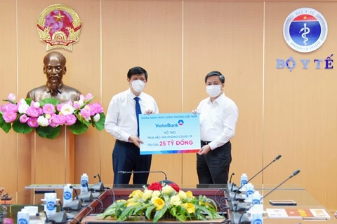 Ông Lê Đức Thọ - Ủy viên Ban chấp hành Trung ương Đảng, Chủ tịch HĐQT VietinBank trao ủng hộ 25 tỷ đồng mua vaccine. (Ảnh: Vietnam+)