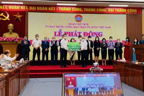 Lãnh đạo Vietcombank trao ủng hộ cho đại diện Ủy ban Trung ương Mặt trận Tổ quốc Việt Nam. (Ảnh: Vietnam+)
