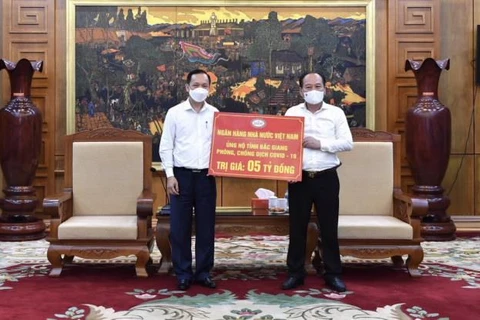 Phó Thống đốc NHNN Đào Minh Tú trao ủng hộ cho lãnh đạo tỉnh Bắc Giang (Ảnh: CTV/Vietnam+)