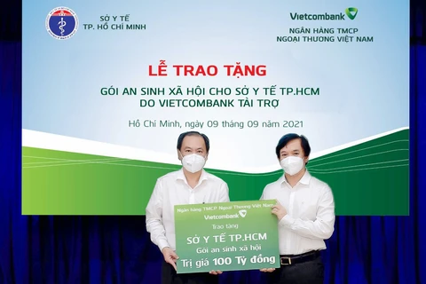Ông Đặng Hoài Đức, Phó Tổng Giám đốc Vietcombank (bên phải) trao biển tượng trưng tài trợ cho đại diện Sở Y tế Thành phố Hồ Chí Minh. (Ảnh: Vietnam+)