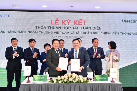 Ông Nguyễn Thanh Tùng - Phó Tổng Giám đốc Phụ trách BĐH Vietcombank (bên phải) và ông Huỳnh Quang Liêm - Tổng Giám đốc VNPT ký thỏa thuận hợp tác toàn diện. (Ảnh: Vietnam+)