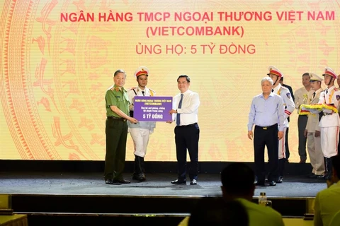 Ông Nguyễn Thanh Tùng - Phó Tổng Giám đốc phụ trách Ban điều hành đại diện Vietcombank ủng hộ Quỹ 5 tỷ đồng. (Ảnh: Vietnam+)